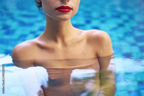Beauty and skin care. Portrait of sensual young woman red lips make-up in swimming pool. © luengo_ua