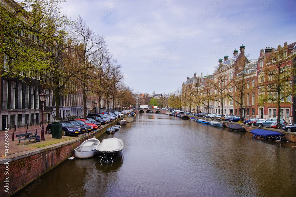 Boats on canal of Amstel River and buildings Amsterdam