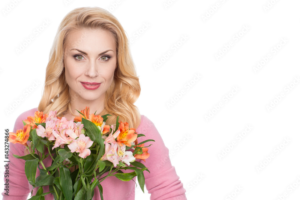 Natural beauty. Gorgeous mature woman holding flowers smiling to the camera copyspace on the side