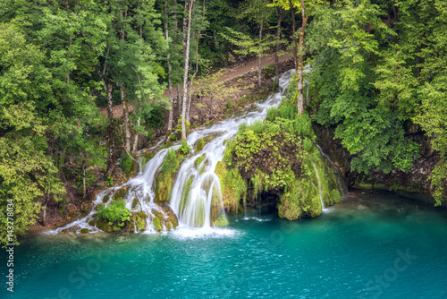 Tourist route in the green summer forest with waterfall  Plitvice Lakes National park  Croatia. Nature background suitable for guide book