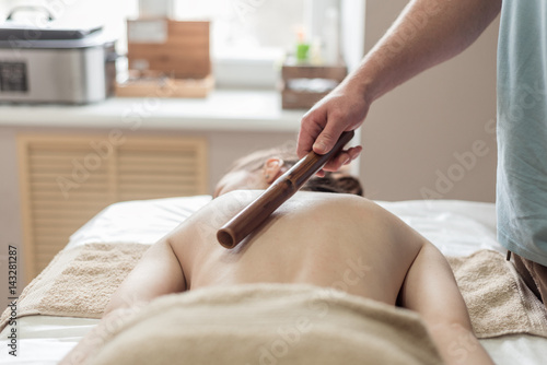 Young woman getting bamboo massage. photo