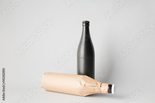 The composition of two bottles: one stands and the other is tipped over