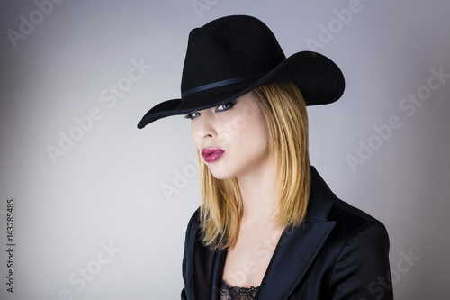 Portrait  d'une jeune femme avec un chapeau noir, le regard vers l'objectif  © Warpedgalerie