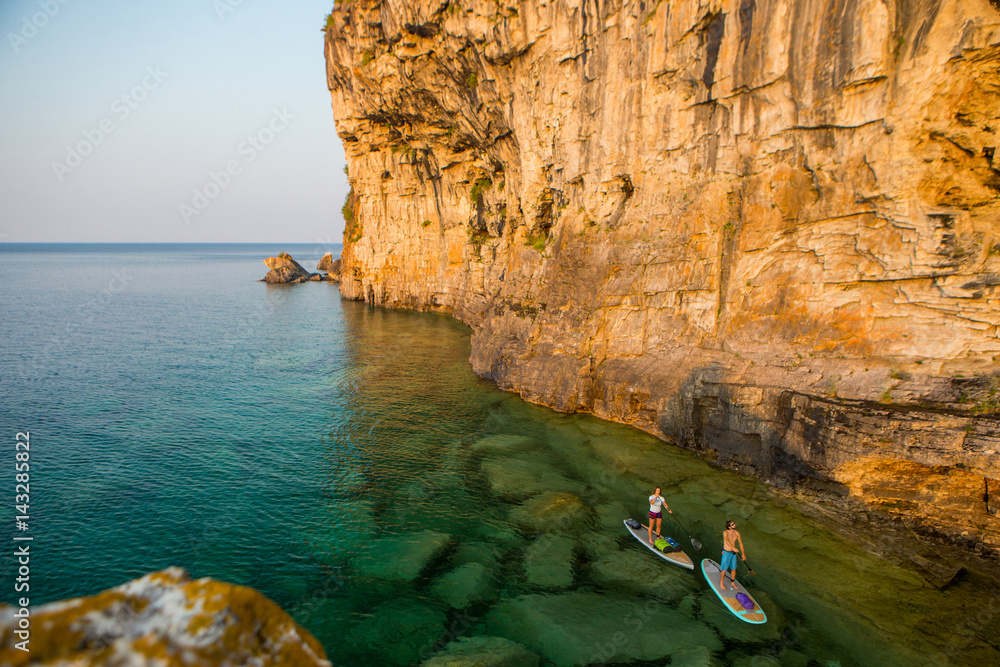 Attractive Young couple Stand Up Paddle Boarding,