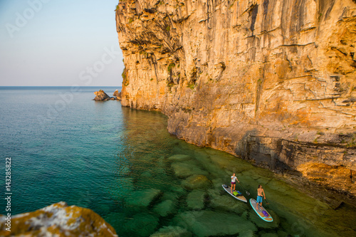 Obraz na płótnie Attractive Young couple Stand Up Paddle Boarding, w salonie