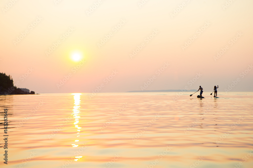 Attractive Young couple Stand Up Paddle Boarding,