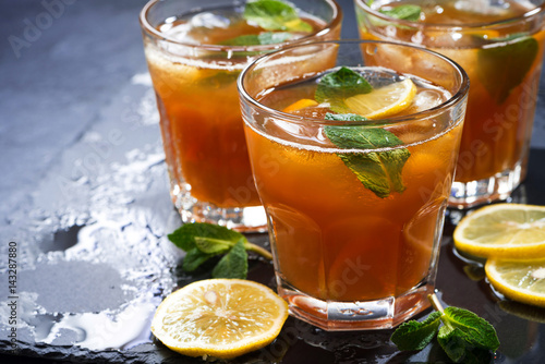 iced tea with mint and lemon on dark background