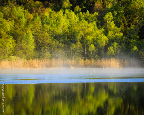 Early morning mist on lake during fall in Sweden