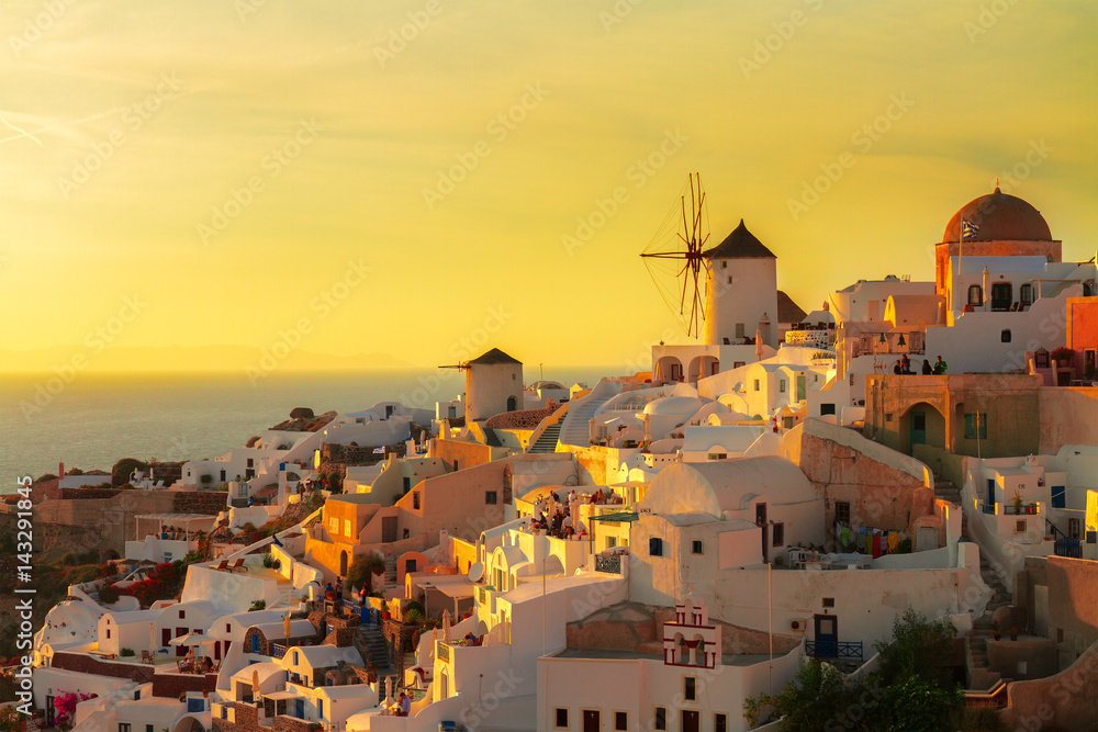 Fototapeta premium famouse soft orange sunset of Oia with windmill, Santorini island