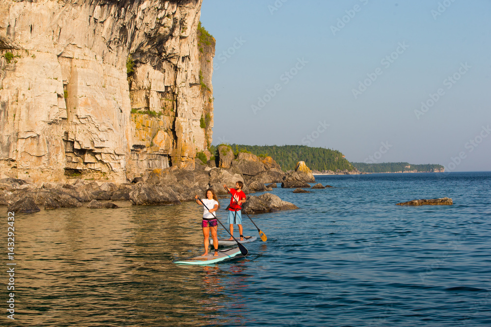 Attractive Young couple Stand Up Paddle Boarding