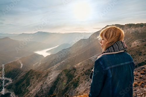 Beautiful girl on top of mountain watching sunrise