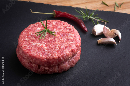 Hamburguesa cruda con condimentos