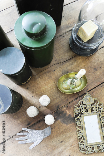 Atmosphere and objects of vintage decoration and chiné with mirror, metal boxes and candlestick on an old wooden table photo