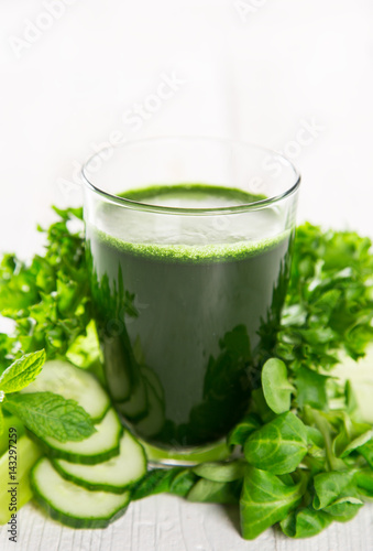 Healthy green smoothie in a glass with vegetables.