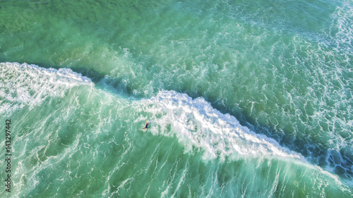 Aerial view of surfer on huge ocean wave