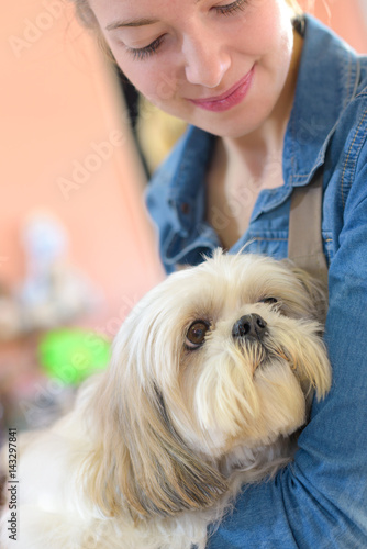 portrait of young woman and her dog in pet store