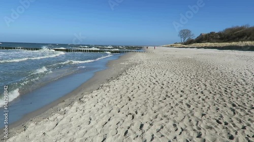 walking along the beach of ahrenshoop with its dunes and reed houses (Germany)