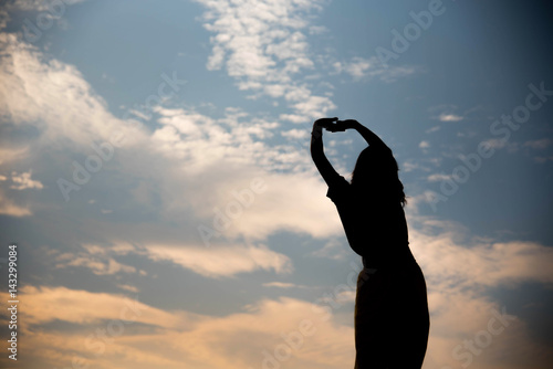 Silhouette woman happy at sunset sky outdoor