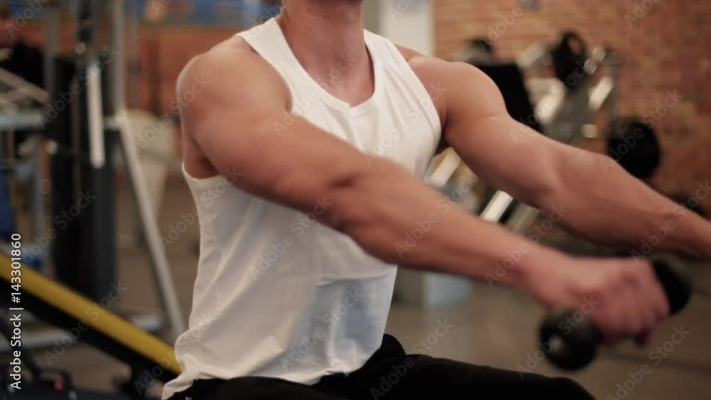 Male athlete rowing on gym machine Male athlete rowing on gym machine