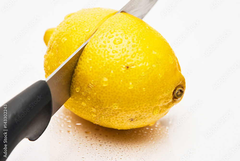 Yellow lemon on the white background cut with knife