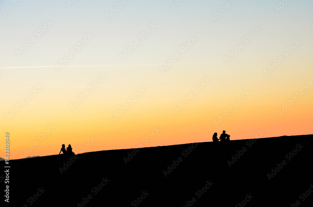 Silhouette of two couples at sunset on the beach