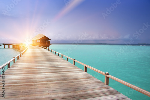 The wooden road over the sea to traditional lodges on piles