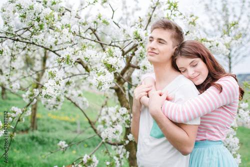Verliebtes Paar Frau umarmt Mann bei blühendem Kirschbaum © Nena