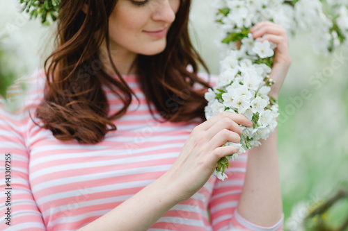 Mädchen streichelt weiße Blüten im Frühling