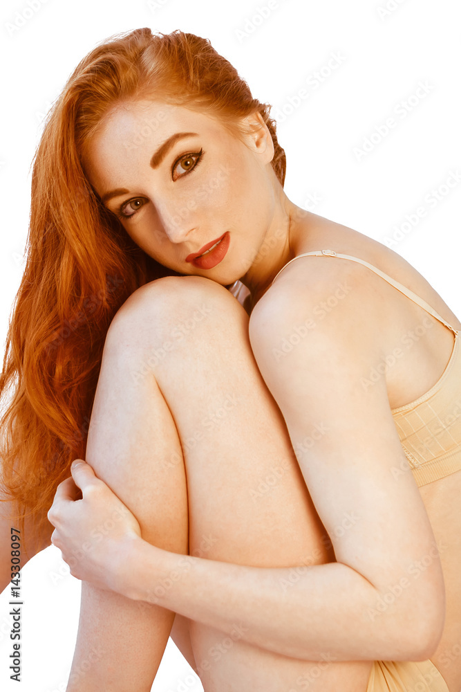 young redhead woman in beige underwear sitting on floor. lingerie picture of healthy redhead woman over white young redhead woman in beige underwear sitting on floor. lingerie picture of healthy redhead woman over white