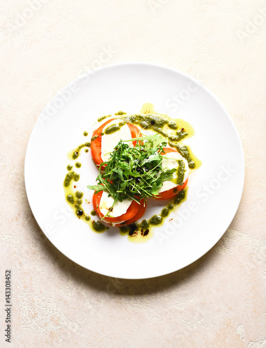 Tasty tomatoes sliced with mozarella cheese and green arugula salad