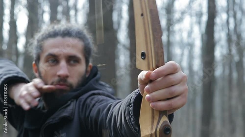 Man shoot with a bow in the forest photo