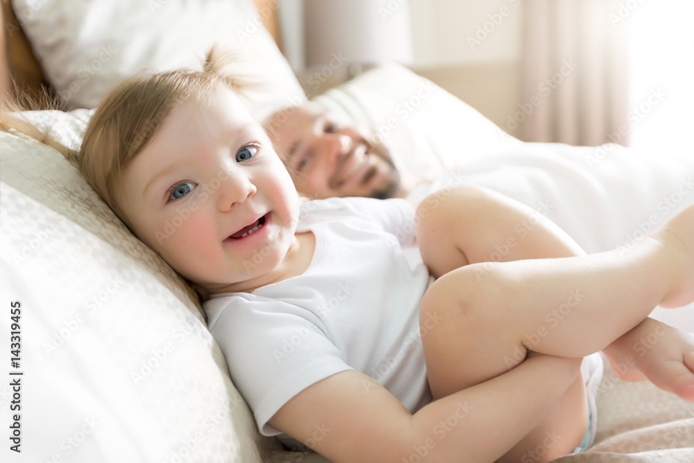 Father with adorable baby toddler on bed Father with adorable baby toddler on bed