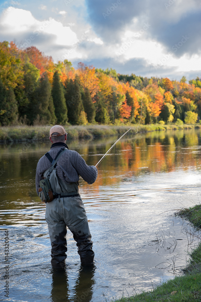 Man fly fishing in the fall in a river