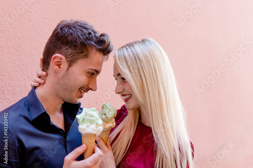 Verliebtes Paar mit Eistüten vor roter Wand