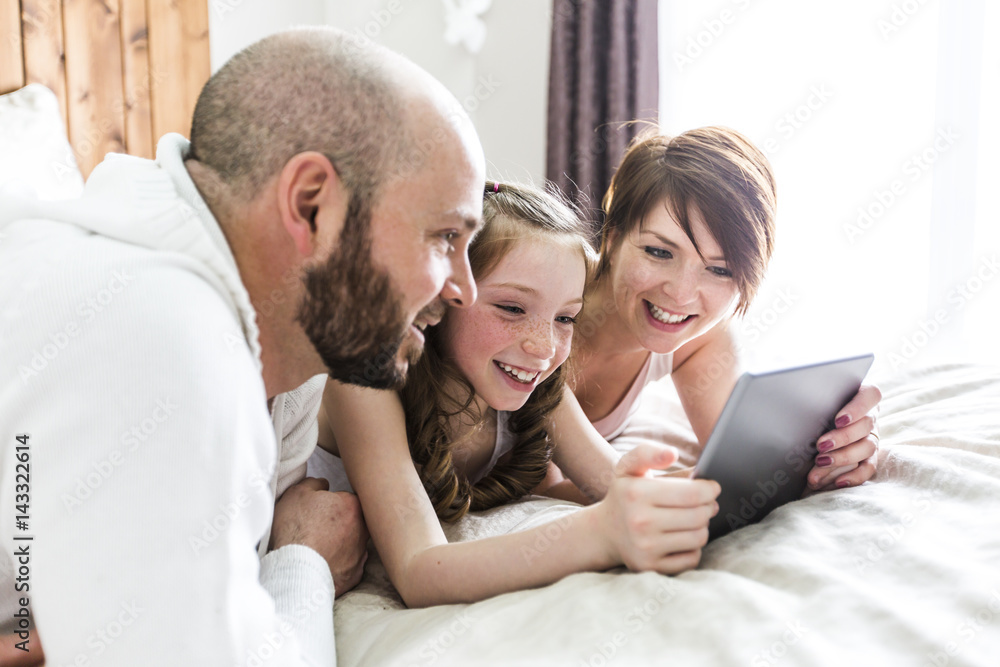 Mother father and her child with digital tablet relaxing at home