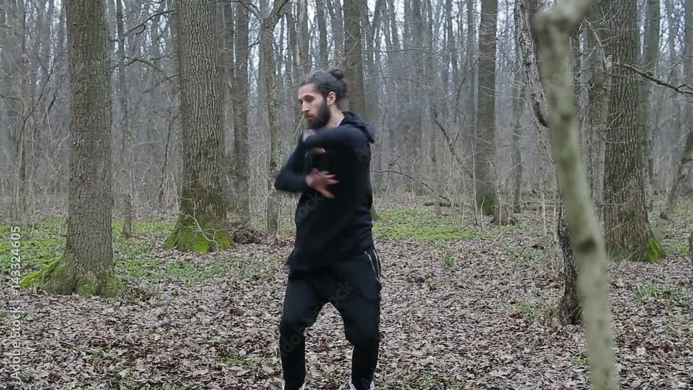 Master wushu and tai chi practiced in the forest in spring Master wushu and tai chi practiced in the forest in spring
