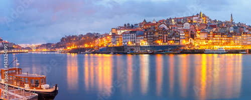 Ribeira and Old town of Porto with mirror reflections in the Douro River during evening blue hour, Portugal, Portugal. © Kavalenkava