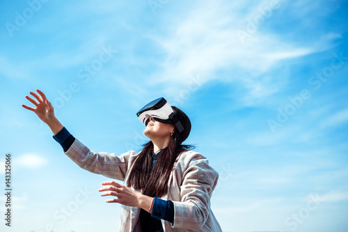 Pretty girl outdoor enjoying virtual reality glasses
