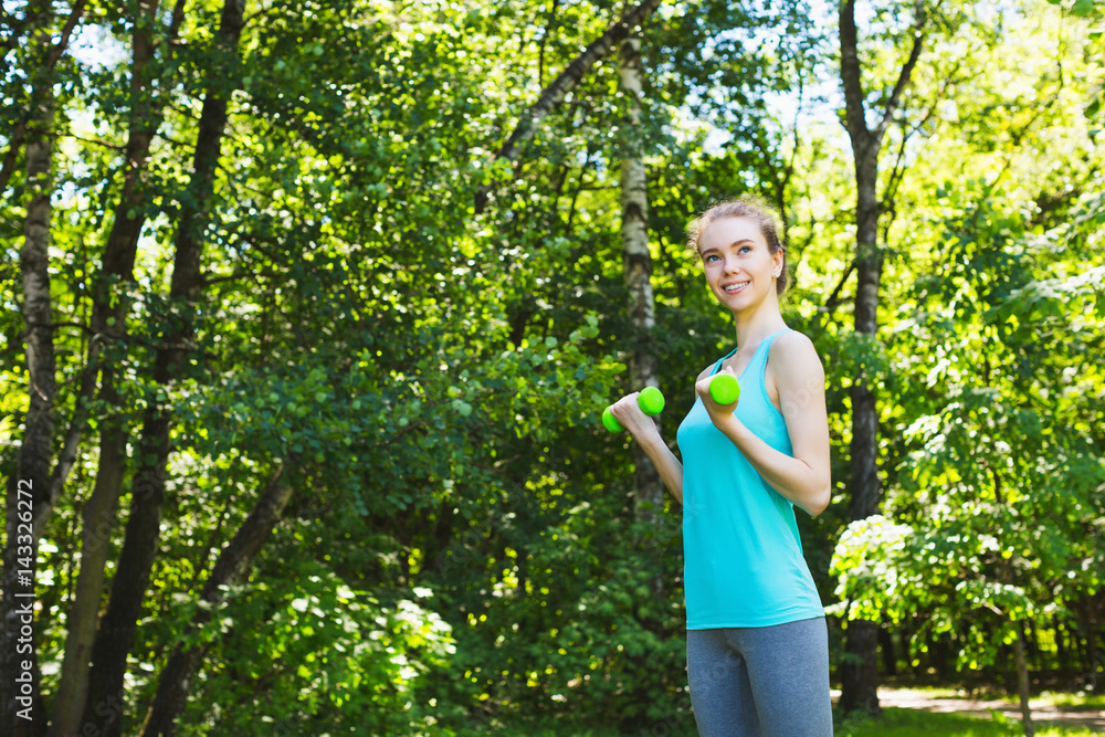 Sport woman doing exercises with dumbbells outdoors. Sport woman doing exercises with dumbbells outdoors.