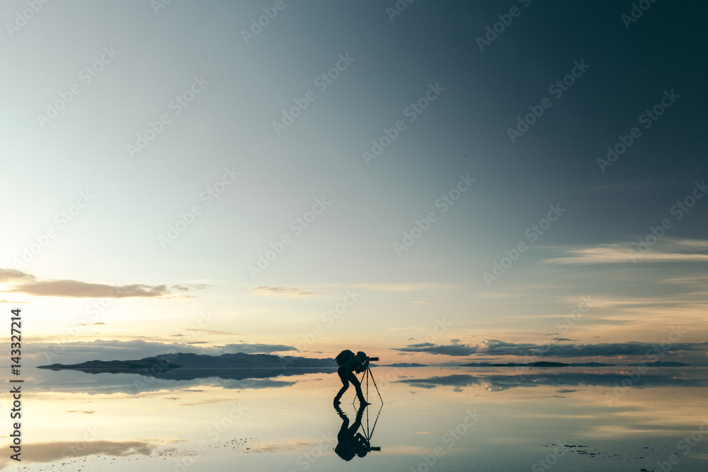 Silhouette of photographer taking picture with camera against sky