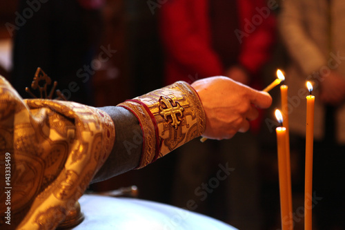 Fotografering the Orthodox priest lights the candles during the baptismal ceremony