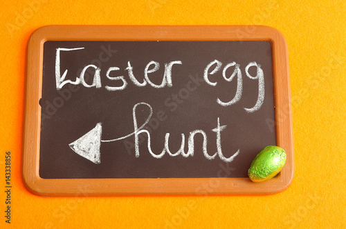 Fototapeta Naklejka Na Ścianę i Meble -  A blackboard with the words easter egg hunt and a green easter egg