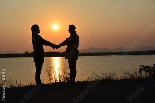 people holding hand on nature background with sun, silhouette style