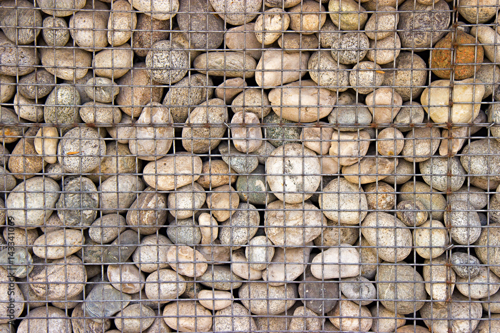 different light pebble stones in iron mesh background texture. creative wall decoration different light pebble stones in iron mesh background texture. creative wall decoration