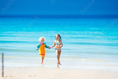 Kids run and play on tropical beach