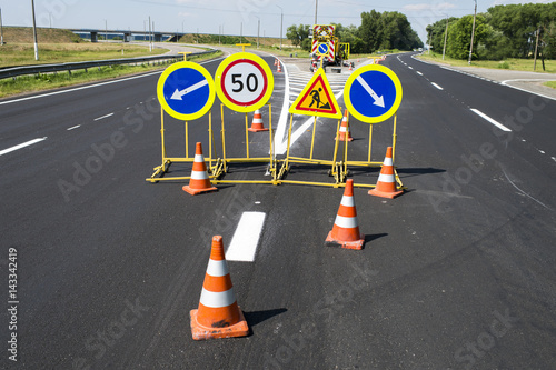 traffic signs during repair and paint work on the fenced road cones