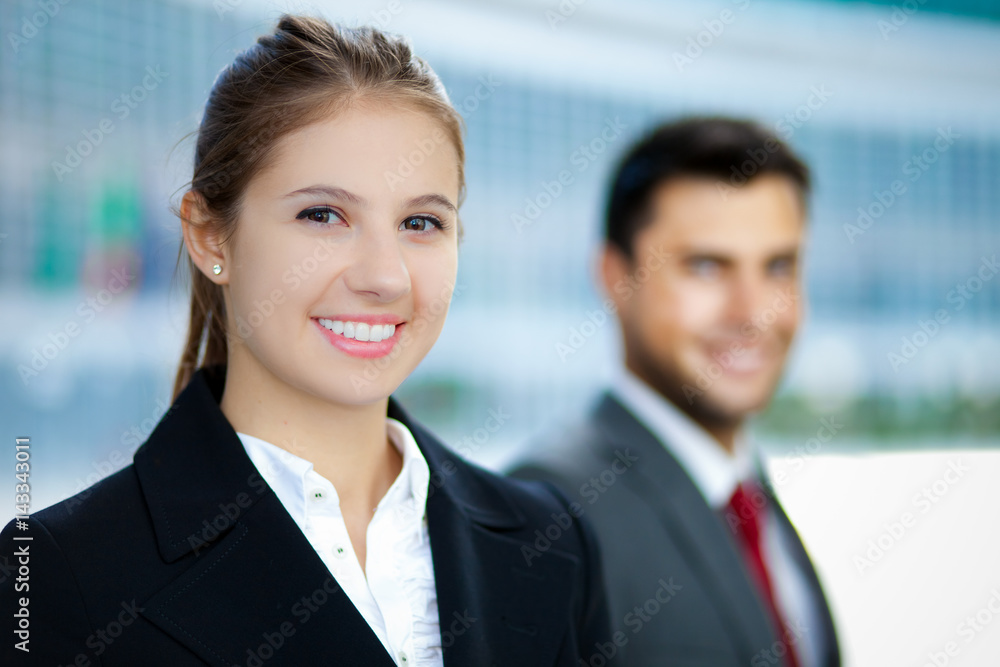 Two business people smiling in an urban setting