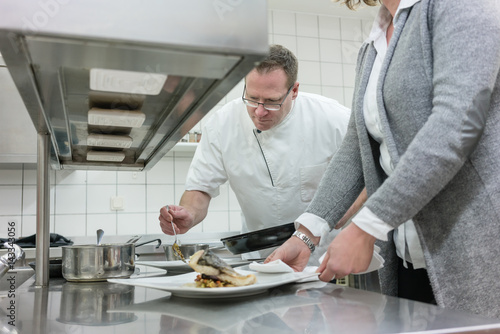 Service waitress and chef working together in restaurant kitchen