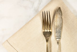 Vintage fork and knife on white marble table with copyspace