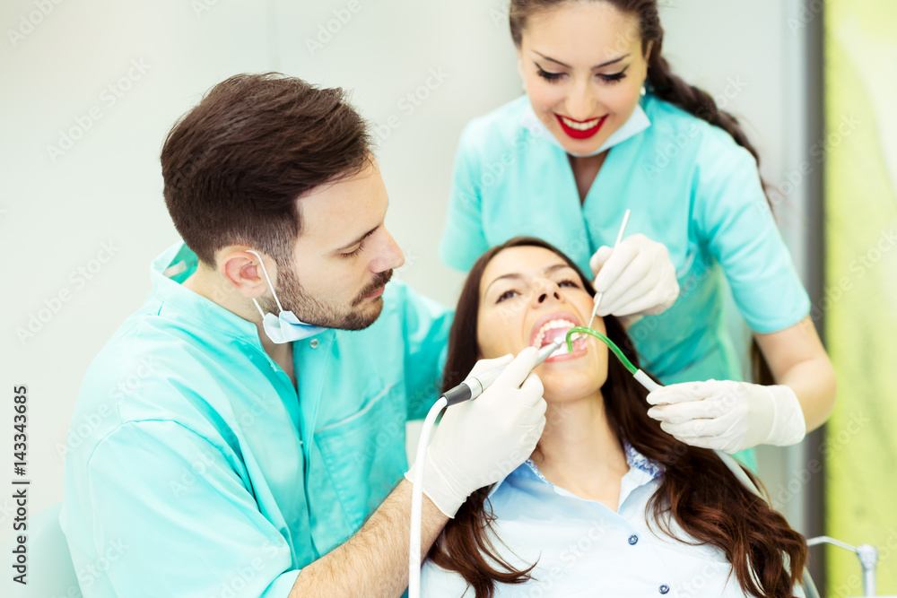 A dentist with assistant working on a patient A dentist with assistant working on a patient